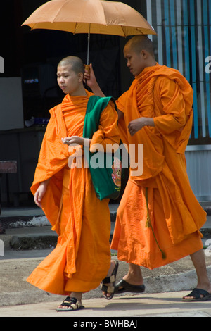 Los dos monjes budistas están caminando por una calle de Mae Hong Son, Tailandia. Foto de stock