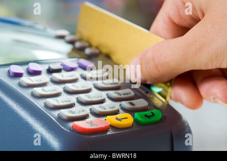 Close-up de pago los botones de la máquina con la mano humana la celebración de cerca por tarjeta de plástico