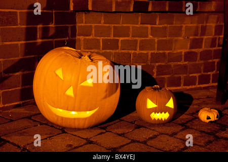 Tres calabazas, pequeños, grandes y pequeños, en la noche de Halloween