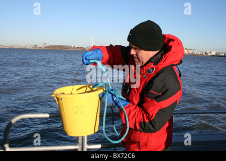 Científico Marino toma de muestras de agua en el río Mersey, Liverpool, Reino Unido Foto de stock