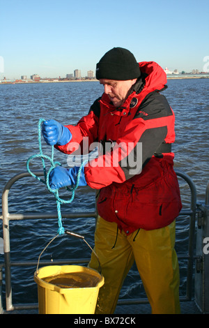 Científico Marino toma de muestras de agua en el río Mersey, Liverpool, Reino Unido Foto de stock
