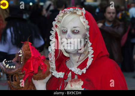  Mujer vestida como Caperucita Roja sosteniendo una cabeza cortada del lobo en el Greenwich Village de   Desfile de Halloween en NYC Fotografía de stock