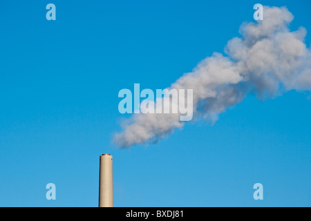Humo proveniente de plantas de energía de carbón chimney contra el cielo azul. Símbolo del calentamiento global y la contaminación por humo. Foto de stock