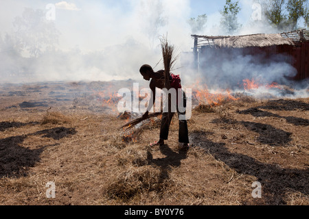 MUECATE distrito cerca de Nampula, Mozambique, en mayo de 2010 : un trabajador agrícola se quema de rastrojo y hierba en una granja. Foto de stock