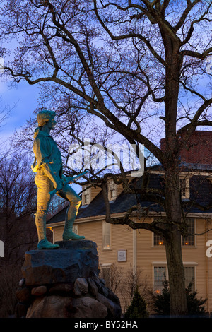 El atardecer en el Minuteman estatua con Buckman Tavern más allá de Lexington, Massachusetts, EE.UU.