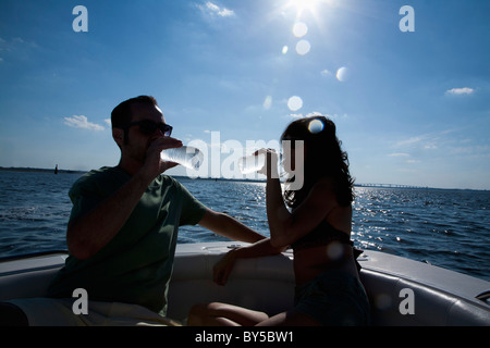 Una pareja en su barco beber agua embotellada