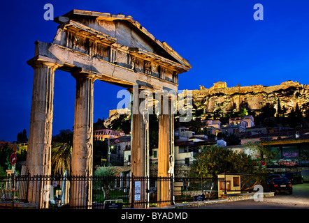 La Puerta de Atenea Archegetis, en el lado oeste del Ágora Romana de Atenas en Plaka, en la noche. En el fondo la Acrópolis Foto de stock