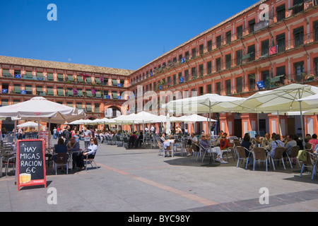 La Plaza de la Corredera, Córdoba, España. La gente disfruta del sol en los cafés al aire libre. Foto de stock