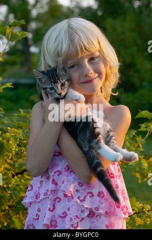 Retrato de niña abrazando cat afuera