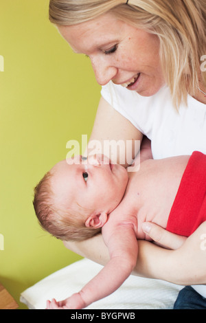 Mujer adulta media holding recién nacido