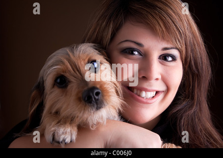 Una joven en su 20s tiene un lindo yorkshire terrier beagle de raza mixta ( también conocido como un perro borkie ).
