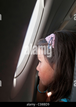 Niño en un avión, mirando por la ventana