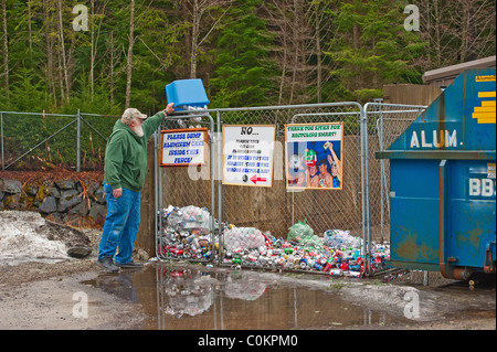 Las escuelas comunitarias Sitka, 'Re-ciclo' centro de acopio en Sitka Sitka, Alaska. Hombre de Alaska el dumping de latas de aluminio en la bandeja. Foto de stock