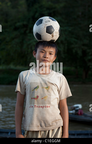 Karen (Kariyan) aldea de refugiados boy jugar con pelota de fútbol, Huay Pu Keng, Mae Hong Son Foto de stock