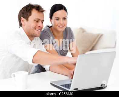 Lindo hombre mostrando algo en la pantalla del ordenador portátil a su novia