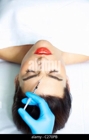 La mujer que recibe la inyección de Botox en la frente