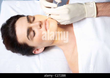 La mujer que recibe la inyección de Botox en los labios