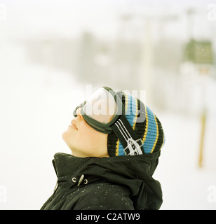 Mujer vistiendo gafas de esquí mirando hacia arriba