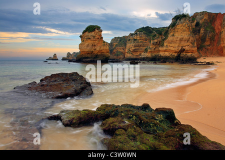 Suave luz de la mañana sobre las fascinantes formaciones de roca en Praia Dona Ana, cerca de Lagos, en la región de Algarve de Portugal