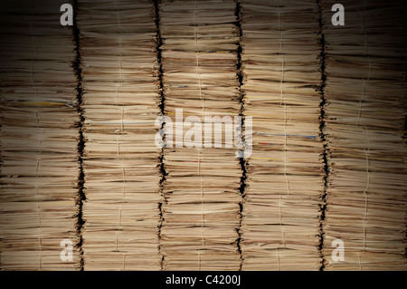 Cinco montones de periódicos uniforme para ser reciclados, iluminado desde arriba Foto de stock