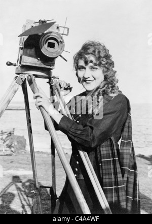 Vintage foto circa 1916 de origen canadiense actriz Mary Pickford (1892 - 1979) de pie junto a una cámara de imágenes en movimiento. Foto de stock