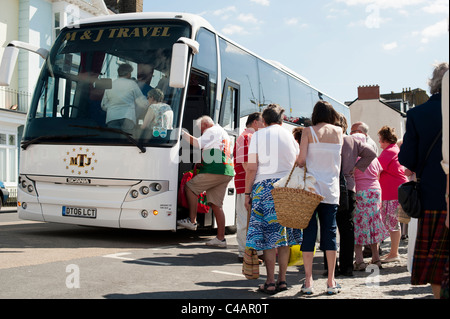 Los excursionistas de vacaciones subirte a un autobús autobús en Aberystwyth promenade, Gales, Reino Unido Foto de stock