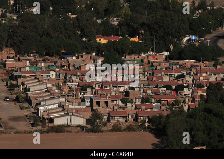 Zoom shot, mirando hacia abajo desde el Cerro la Gloria, suburbano de casas de ladrillo rojo en el sur-oeste de las afueras de Mendoza, Argentina.