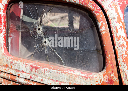 Old Ford pick up puerta con dos orificios de bala en el cristal de la ventana. Foto de stock