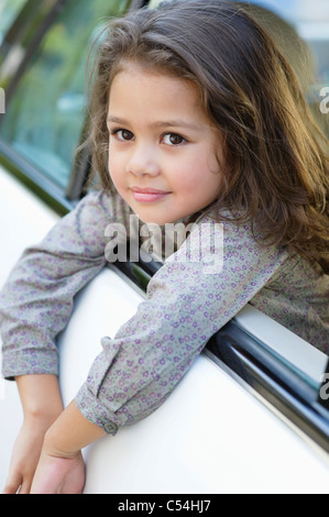 Cute Little Girl mirando afuera de la ventanilla del automóvil