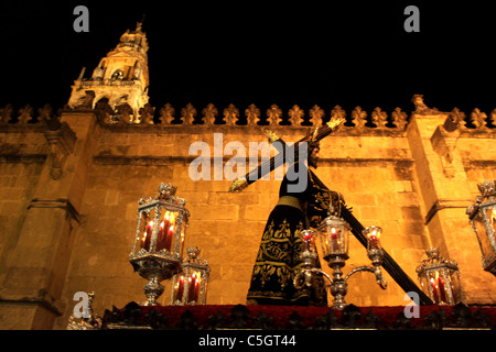 Un trono mostrando el Señor de los Reyes pasa él Mezquita-catedral durante una procesión de Semana Santa en Córdoba, España Foto de stock