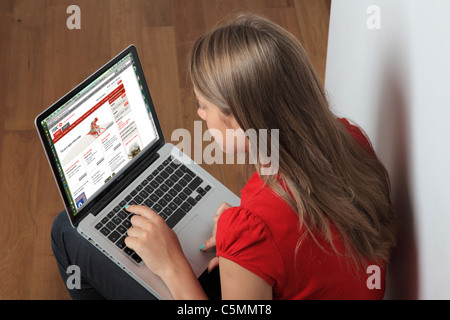 Joven con un portátil en la página del banco HSBC, la banca online. Foto de stock