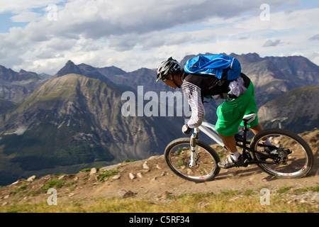 Italia, Livigno, visión del hombre montando en bicicleta de montaña cuesta abajo