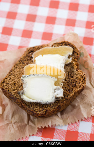 Rodajas de pan de jengibre con queso de cabra y gengibre confitado Foto de stock