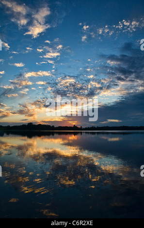 La puesta de sol se refleja en un plácido lago en el norte de Minnesota, EE.UU. Foto de stock