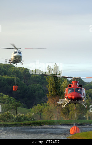 Helicóptero Bell 412 recogiendo agua, Cabopino Golf, Costa del Sol, Málaga, Andalucía, España, Europa Occidental.