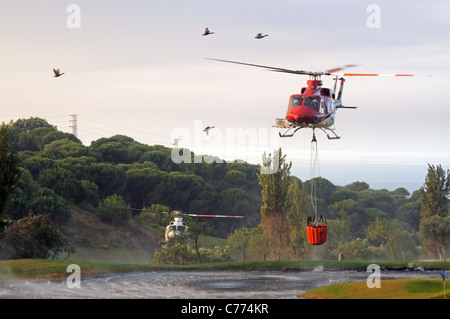 Helicóptero Bell 412 recogiendo agua, Cabopino Golf, Costa del Sol, Málaga, Andalucía, España, Europa Occidental.