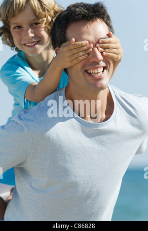 Boy cubriendo ojos del padre con las manos