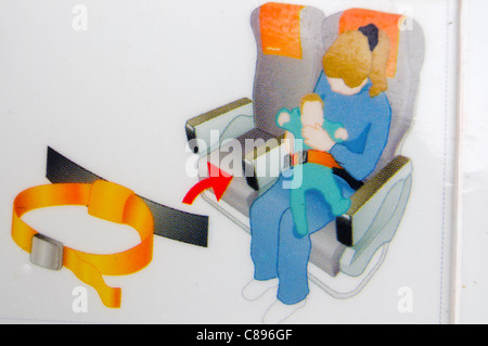 Primer plano de una tarjeta de seguridad aérea que muestra cómo usar un cinturón de seguridad infantil Foto de stock