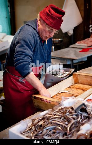 Vendedor venta de pescado fresco en el popular mercado de productos frescos, "Il Capo", en el histórico barrio de 'Capo', Palermo, Sicilia, Italia Foto de stock