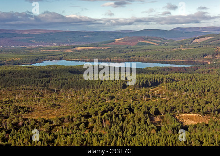 Vista desde Montañas Cairngorm acceso por carretera a través de Rothiemurchus hacia Aviemore con Loch Morlich en el centro Foto de stock