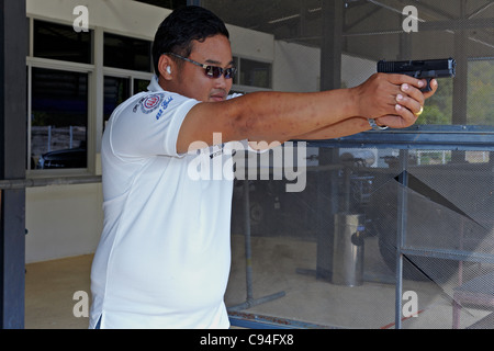 Hombre con ropa táctica disparando desde una pistola, volviendo a cargar la  pistola y apuntando al objetivo en la zona de tiro de puerta abierta  Fotografía de stock - Alamy