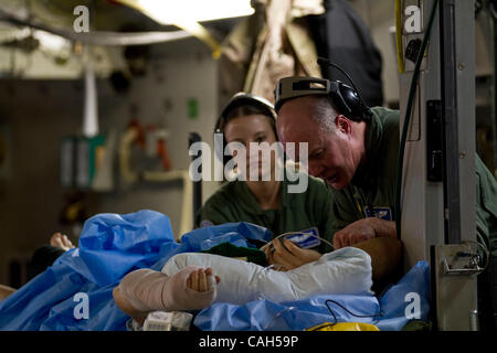Enero 13, 2011 - Ramstein, Alemania - EE.UU. la Fuerza Aérea capitán Cook Erskine, enfermera de vuelo, justo y Senior Airman AUDREY GORDON, ambos miembros del 86º Escuadrón de la evacuación aeromédica (AES) con sede en la base aérea de Ramstein, Alemania, tienden a un soldado herido gravemente heridos en Afganistán a bordo de un Missis Foto de stock