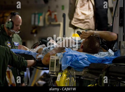 Un soldado herido gravemente heridos en Afganistán , es atendido por miembros del 86º Escuadrón de la evacuación aeromédica (AES) con sede en la base aérea de Ramstein, Alemania, mientras que a bordo de un Guardia Nacional Aérea de Mississippi C-17 avión de carga en la ruta a la base de la Fuerza Aérea Andrews, Maryland, enero, 11, 2011. Wounde Foto de stock