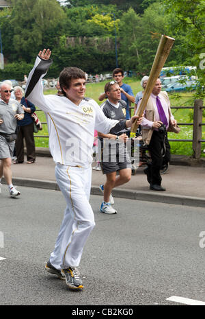 Juan Lewis, de 16 años de edad de Llanbradach carryng la llama durante los relevos de la antorcha para los Juegos Olímpicos de Londres 2012 a través de Abergavenny, Gales, Reino Unido el viernes 25 de mayo de 2012 Foto de stock