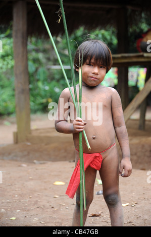 Embera niño jugando a cazar con arco y flecha a la comunidad indígena Embera Puru en Panamá
