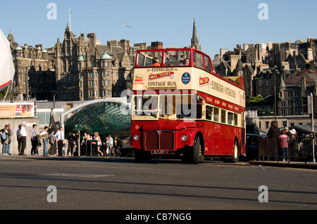 Un ex Londres Routemaster bus está siendo utilizado por Mac Tours alrededor de Edimburgo. El horizonte de la ciudad vieja de Edimburgo está detrás. Foto de stock