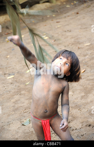 Niño Embera jugando para cazar con hojas de palma en la comunidad indígena Embera Puru en Panamá