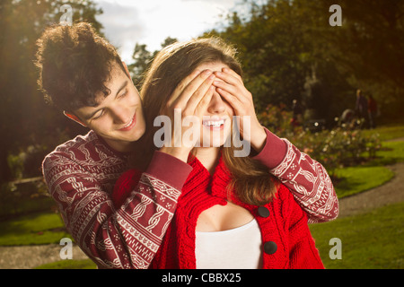 El hombre que cubren los ojos de la novia en el parque