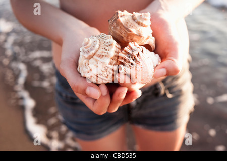 Mujer sosteniendo conchas en la playa
