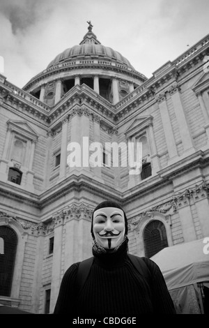 Ocupar Londres manifestante llevaba una máscara de Guy Fawkes de pie delante de la cúpula de la catedral de San Pablo, Londres. 31/10/2011 Foto de stock